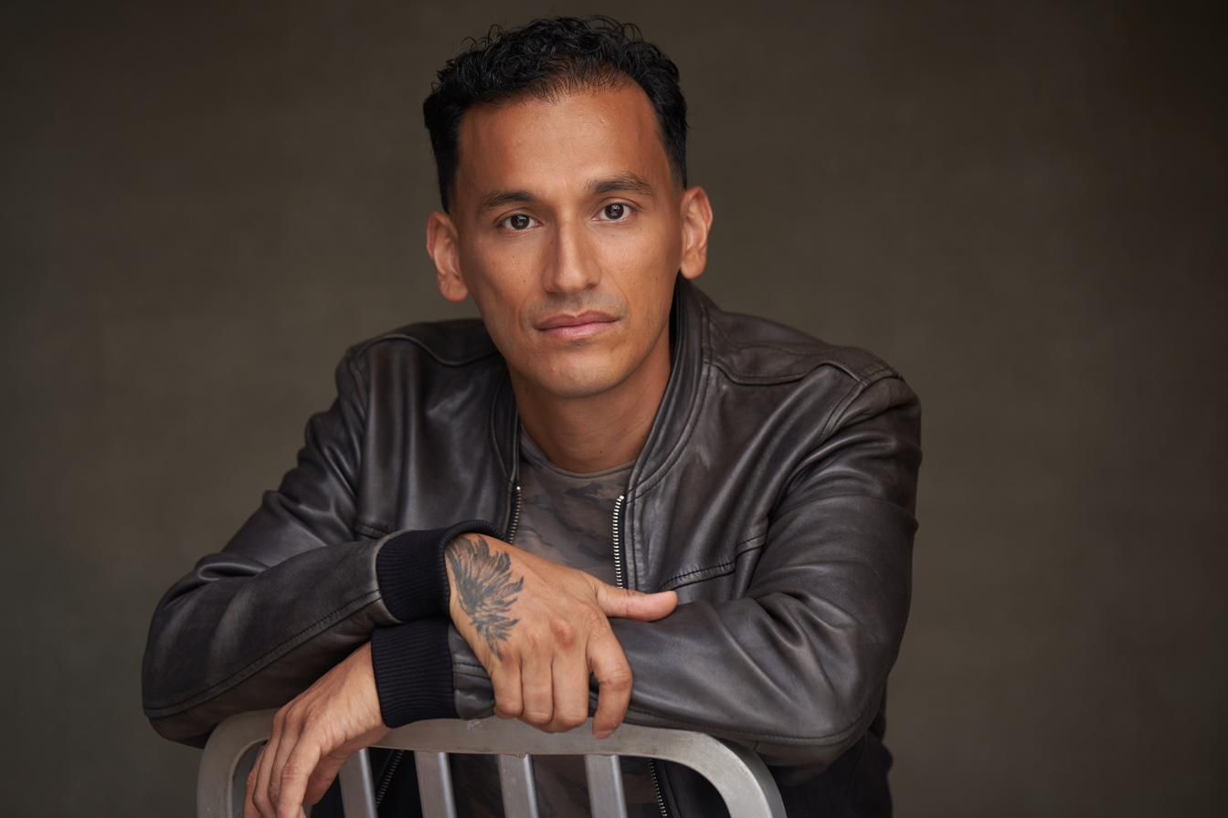 Goya Robles leaning on a chair in studio