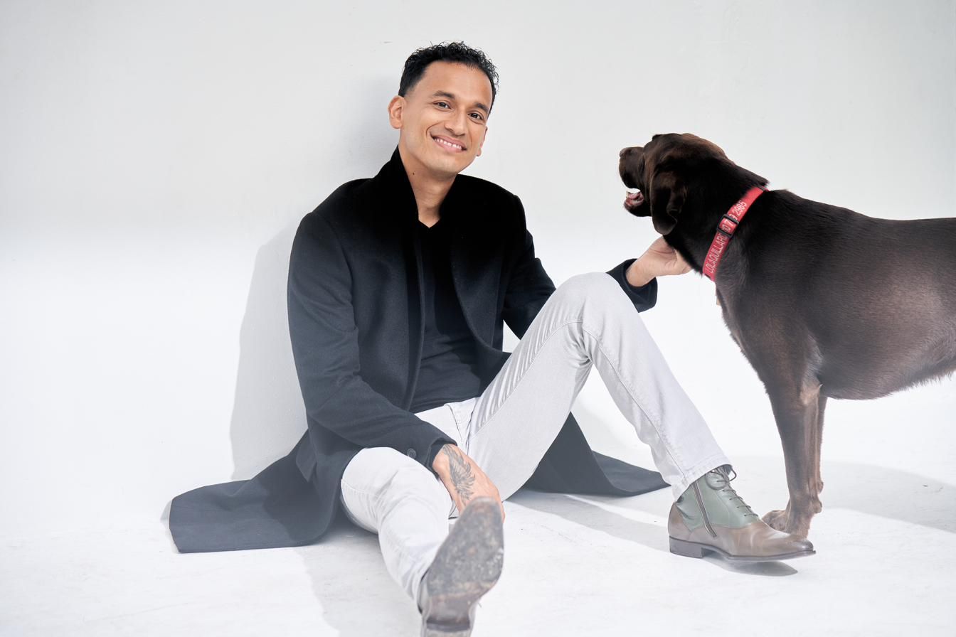 Goya Robles seated with a dog in studio