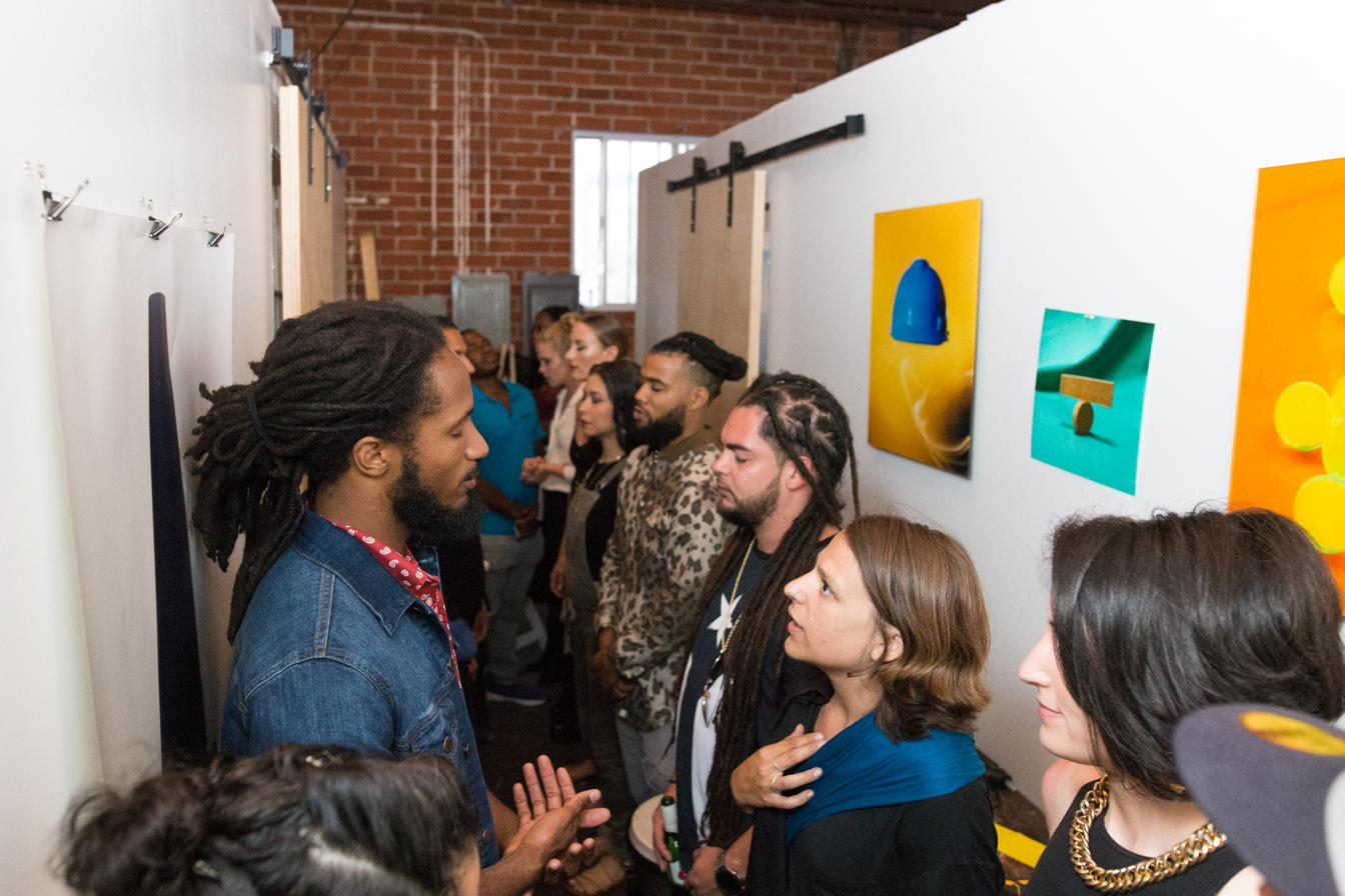 Artists and community members in conversation among the artwork at Paint The Mic
