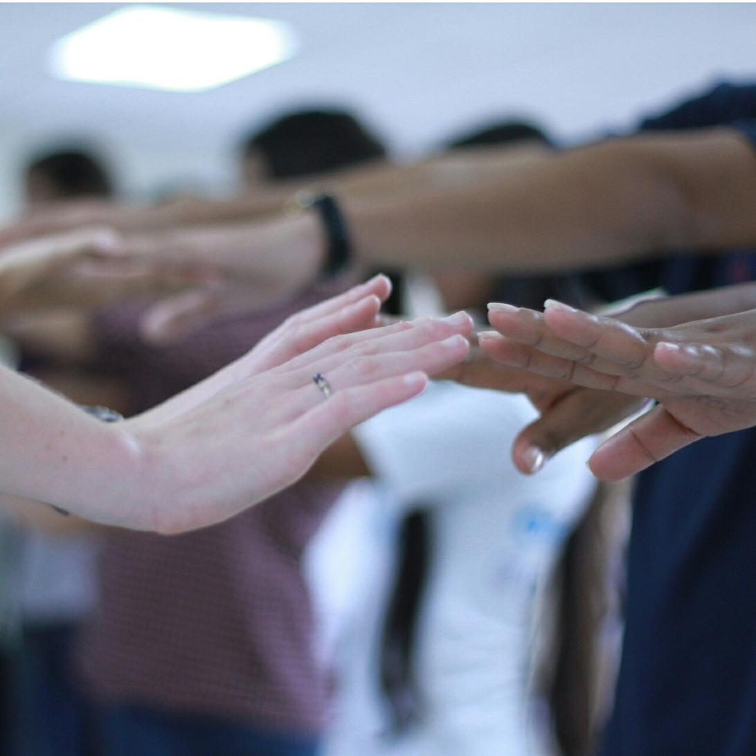 Hands reaching together in an ensemble exercise